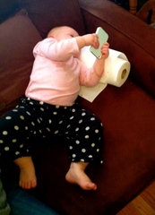 Picture of a toddler totally engaged in the tablet she holds in her hands. catmichaelswriter.com