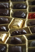 A box of gold-wrapped chocloates in different shapes and sizes