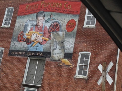 Picture: large painting on old brick factory building: Reist Popcorn Company, Mt. Joy, PA. @ http://www.catmichaelswriter.com/cats-corner-blogging-about-books-writing-and-more/six-simple-ways-to-keep-on-the-write-track 